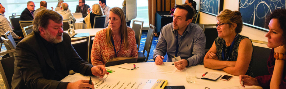 Attendees sitting at a table at the M-Enabling Summit